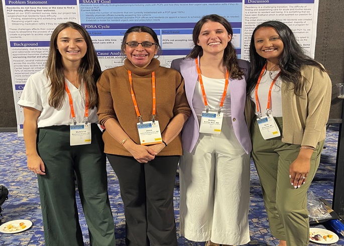 primary care students posing with a poster