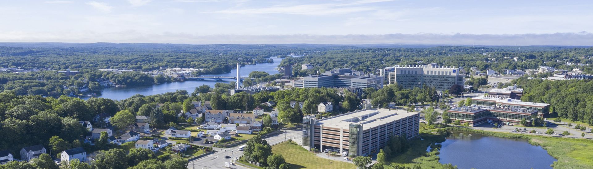 aerial view of a lake and buildings around UMASS Chan area
