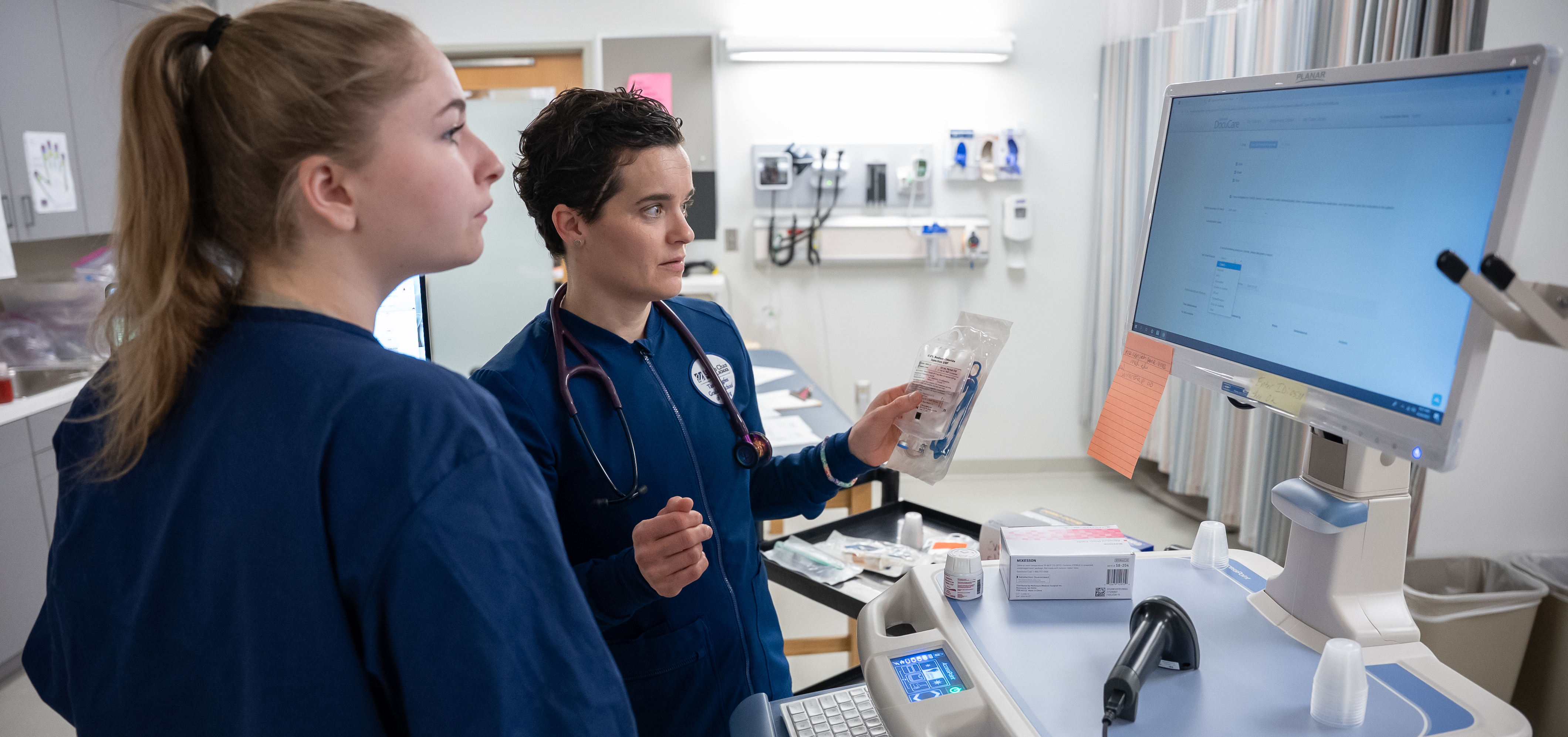 Two nursing professionals looking at a computer screen together