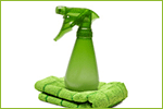 The image shows a green spray bottle and rag