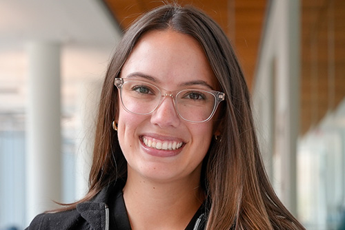 Headshot of Olivia Raymond inside wearing glasses and a black top