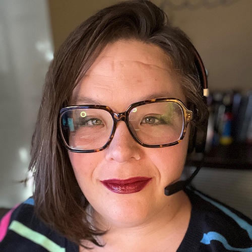 white woman with short dark hair glasses and a headset