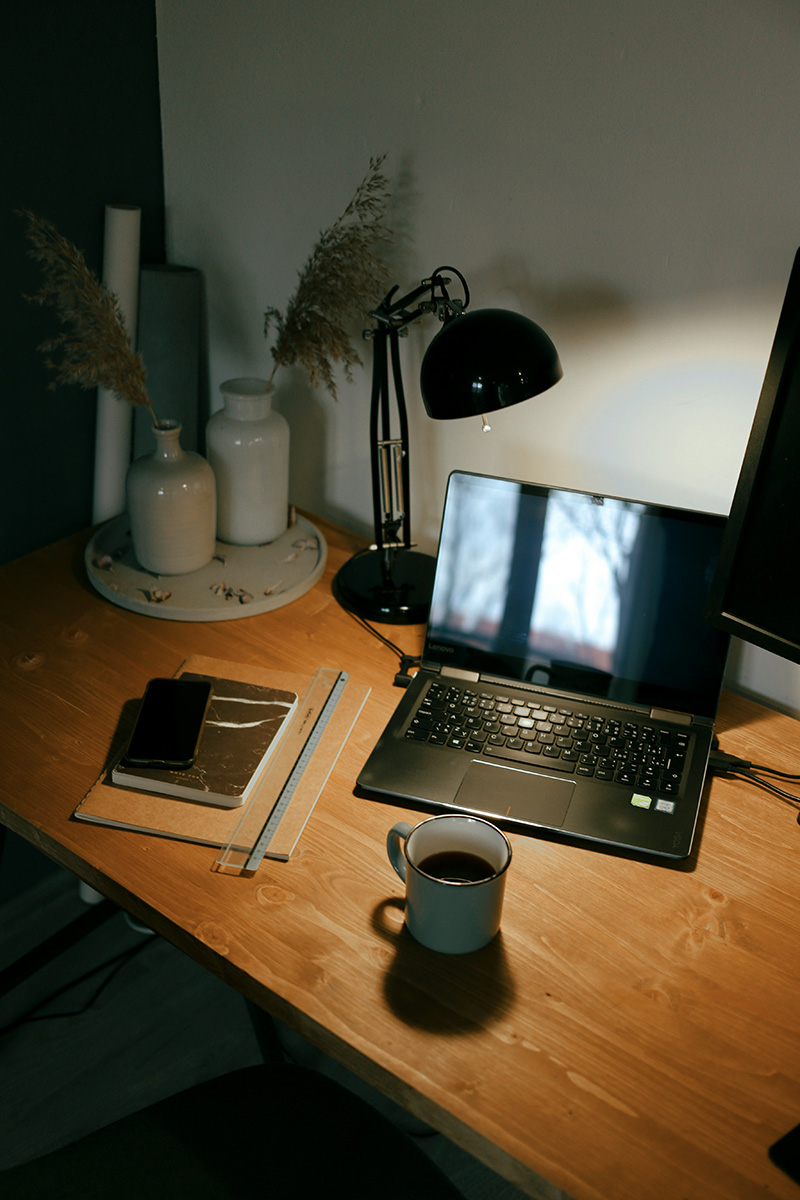 black lamp on a desk with a laptop