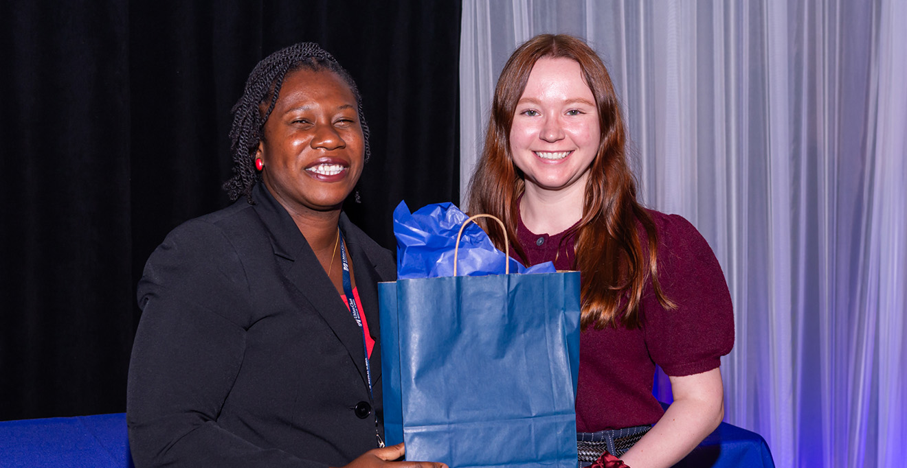 Olufunmilayo &ldquo;Funmi&rdquo; Ayobami, PhD, associate dean for student success and engagement for the Morningside Graduate School of Biomedical Sciences, presents a bag of containing a laser pointer and business cards to PhD candidate Rachel Walker.