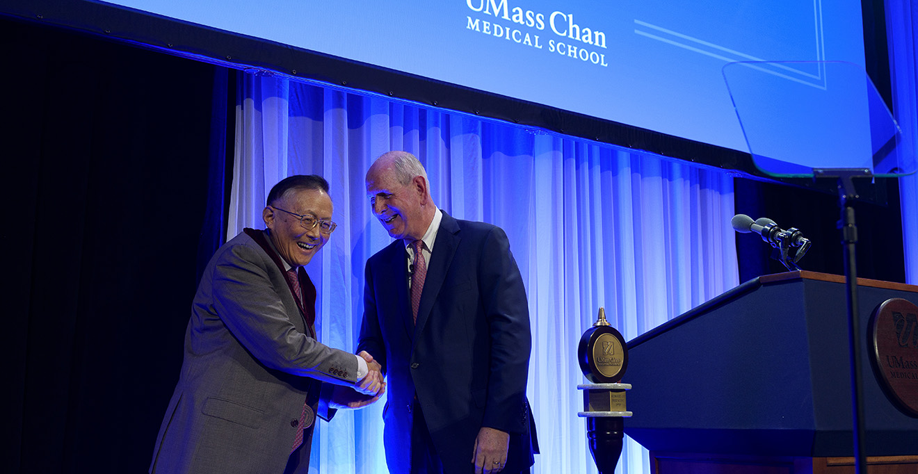 Guangping Gao, PhD, shares a laugh with Chancellor Michael F. Collins after receiving the Chancellor&rsquo;s Medal for Distinguished Scholarship 